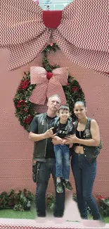 Family with Christmas decor and pink bow background.