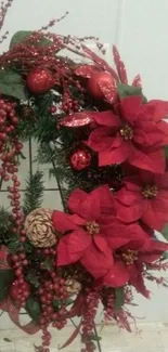 Festive wreath with red poinsettias, pine cones on a phone wallpaper.