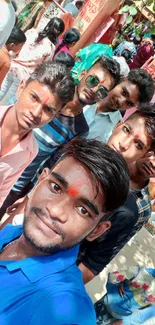 Group of young friends celebrating with colorful festival decor.