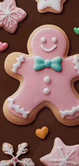 Pink gingerbread cookie with a turquoise bow on a chocolate background.