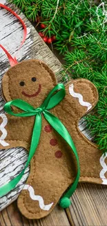 Gingerbread man ornament on rustic wood with green ribbon.