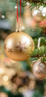 Golden ornament on Christmas tree branch with bokeh lights background.