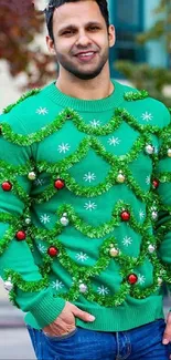 Man wearing a green Christmas decorated sweater outdoors.