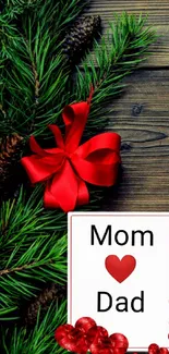 Festive wallpaper with green pine, red bow, hearts, and a card reading 'Mom ❤ Dad'.