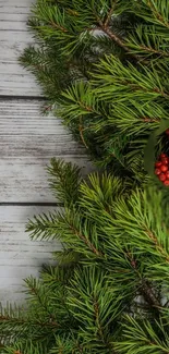 Pine branches and red berries on rustic wood