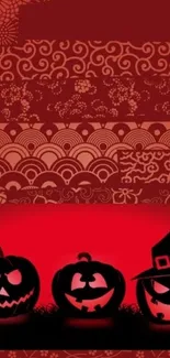 Halloween themed wallpaper with red and black patterns and carved pumpkins.