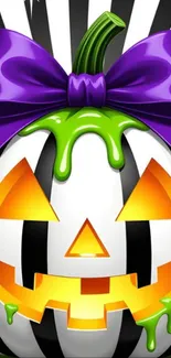 Colorful Halloween pumpkin with a purple bow on a striped background.