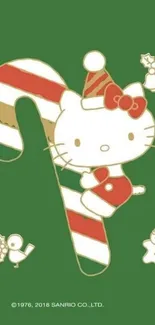 Hello Kitty with candy cane on green Christmas wallpaper.