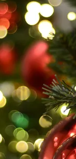 Red holiday ornaments on a Christmas tree with bokeh lights.