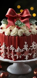 Festive holiday cake with red ribbon and decorations.