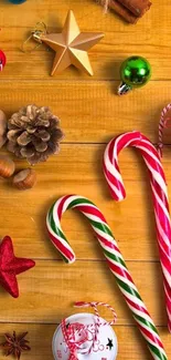 Festive wallpaper with candy canes and holiday ornaments on wooden background.