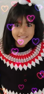 Girl in festive Christmas sweater by holiday decorations.