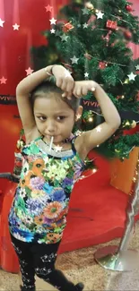 Child in front of a festive Christmas tree wearing colorful attire.