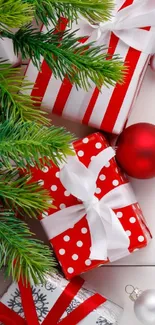 Red and white Christmas gifts with pine branches.