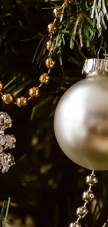 Elegant silver Christmas ornament on green tree with golden beads.