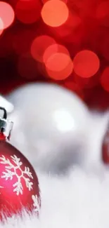 Red and white Christmas ornaments on fluffy snow with festive background.