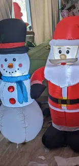 Inflatable Santa and snowman in a cozy room setting.