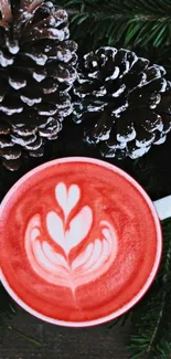 Red latte art in cup with pinecones and greenery.