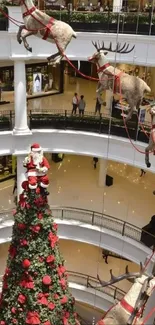 Santa and reindeer in mall Christmas display.