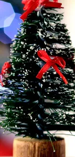 Mini Christmas tree with red bows, festive wallpaper.