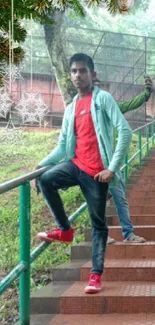 Man on stairs with festive decor and green background.