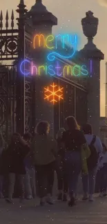 Neon 'Merry Christmas' sign with sunset background.