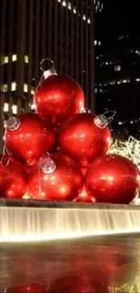 A city night scene with giant red ornaments and lit-up trees.