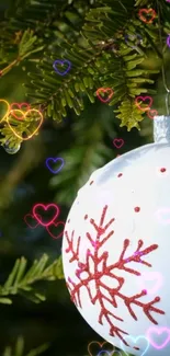 Christmas ornament with hearts and pine tree branches on mobile wallpaper.