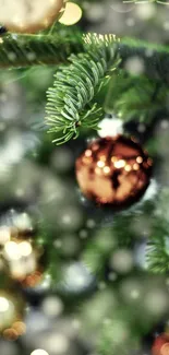 A shiny ornament hangs on a pine branch with a bokeh background.