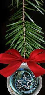 Festive ornament with red bow and stars on pine branch.