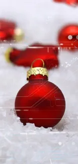 Red ornaments and lit candles on a snowy background.