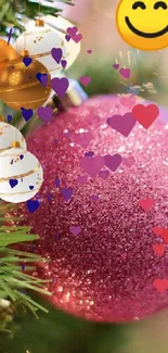 Festive pink ornament and emoji on a Christmas tree.