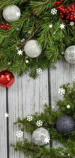 Festive wallpaper with pine branches, berries, and baubles on wood.