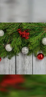 Festive wallpaper with pine branches and colorful baubles.