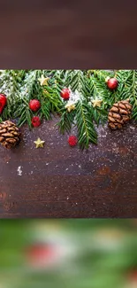 Festive mobile wallpaper with pine cones, greenery, and red ornaments on wood.