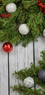 Festive pine branches with holiday ornaments and red berries.