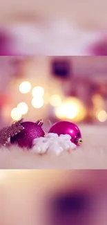 Pink holiday wallpaper with ornaments and bokeh lights.