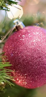 Pink Christmas ornament with bokeh lights background.