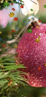 Sparkling pink Christmas ornament on pine.