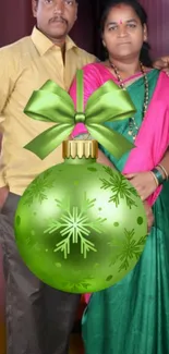 Couple with festive green ornament on holiday-themed wallpaper.