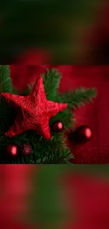 Red star ornament on pine branches, festive Christmas wallpaper.