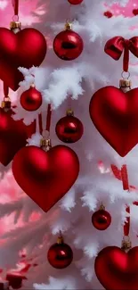 Red heart ornaments on a white Christmas tree with a pink background.