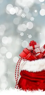 Festive red bag with gifts on snowy background.