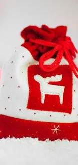 Vibrant red holiday bag with festive reindeer design on snow backdrop.