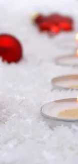 Festive holiday wallpaper with red ornaments and candles on snowy background.