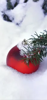 Red Christmas ornament in snowy pine.