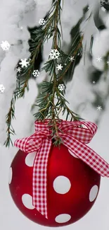 Festive red ornament with polka dots and snow-covered branches.