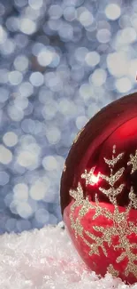 Red Christmas ornament with snowflake on sparkling background.