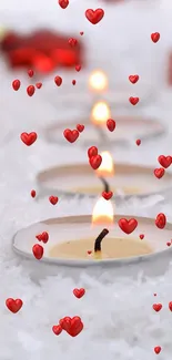 Mobile wallpaper with red ornaments and glowing candles on snow.