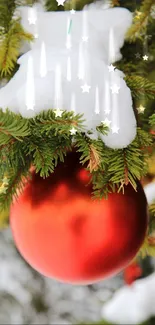 Red ornament on snowy pine branch wallpaper.